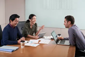 Leoker team in a collaborative meeting, discussing charts and strategies, representing expertise in global trade, supply chain management, and business consulting