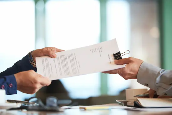 Two professionals exchanging a detailed market analysis report, symbolizing leoker's expertise in providing strategic market intelligence, entry strategies, and business development support for successful trade in china.